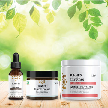 The Sunmed CBD Full Spectrum Anytime Gummies + Neuro Water Soluble + Topical Cream Bundle is displayed on a wooden surface with a leafy background.