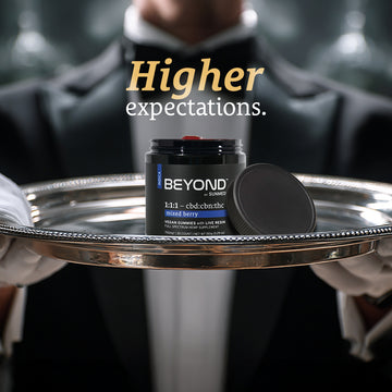 A gloved server holds a tray with a Sunmed CBD Beyond 1:1:1 Indica Live Resin Gummies jar; text reads "Higher expectations.