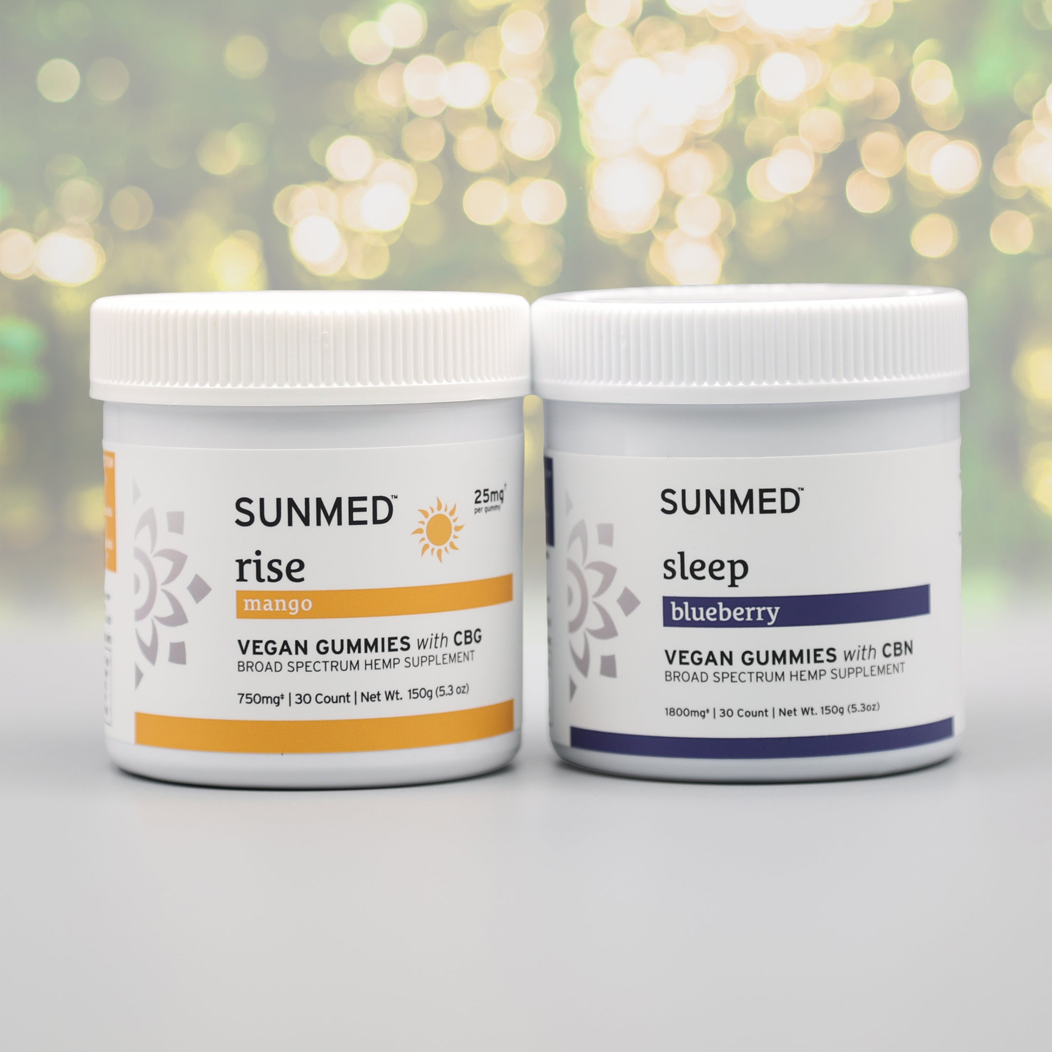 The Sunmed CBD Broad Spectrum Sleep + Rise Gummies Bundle features THC-free CBG "Rise Mango" and CBN "Sleep Blueberry" gummies, ideal for wellness routines. Two jars are shown on a blurred background.