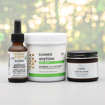 The Sunmed CBD Full Spectrum Anytime Gummies + Water Soluble + Topical Cream Bundle is displayed on a table.