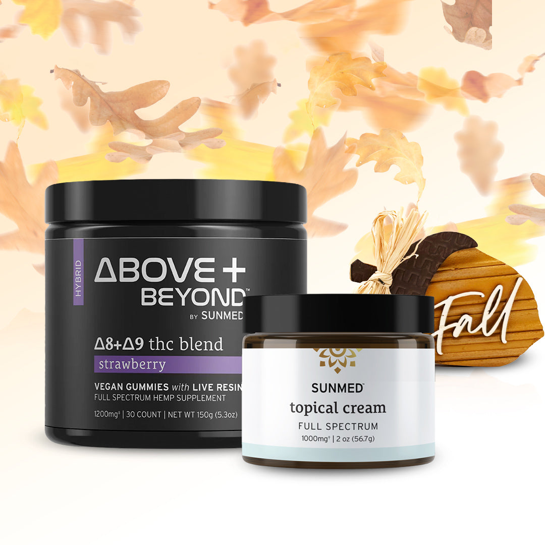 Two jars of Sunmed CBD products from the ABOVE + BEYOND Gummies + Topical Cream Bundle are displayed with fall leaves and a small wooden pumpkin that says “Fall” in the background. One jar features gummies, providing a delicious way to support your daily wellness routine this season.