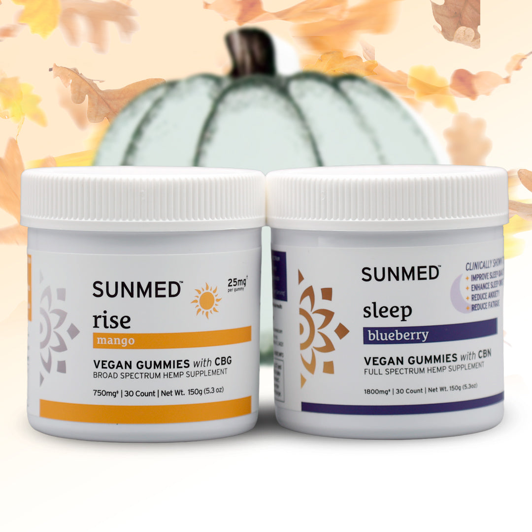 The Sunmed CBD Full Spectrum Sleep + Rise Gummies Bundle features two jars of vegan gummies—mango-flavored Rise gummies and blueberry-flavored Sleep gummies—displayed with a pumpkin and autumn leaves in the background. Experience caffeine-free energy during the day with the Rise gummies, while the CBN-infused Sleep gummies are expertly formulated to help you relax and unwind at night.