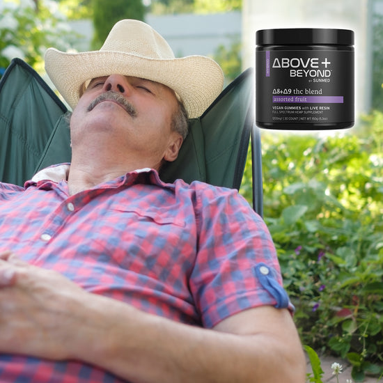 An older man in a straw hat relaxes outdoors with a jar of Sunmed CBD's Above + Beyond Live Resin CBD Gummies beside him.