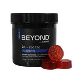A black jar of Sunmed CBD's Beyond 2:1 Indica Live Resin Gummies with three red gummies stacked in front—enjoy the ideal CBD to THC ratio and delicious flavor in these premium treats.
