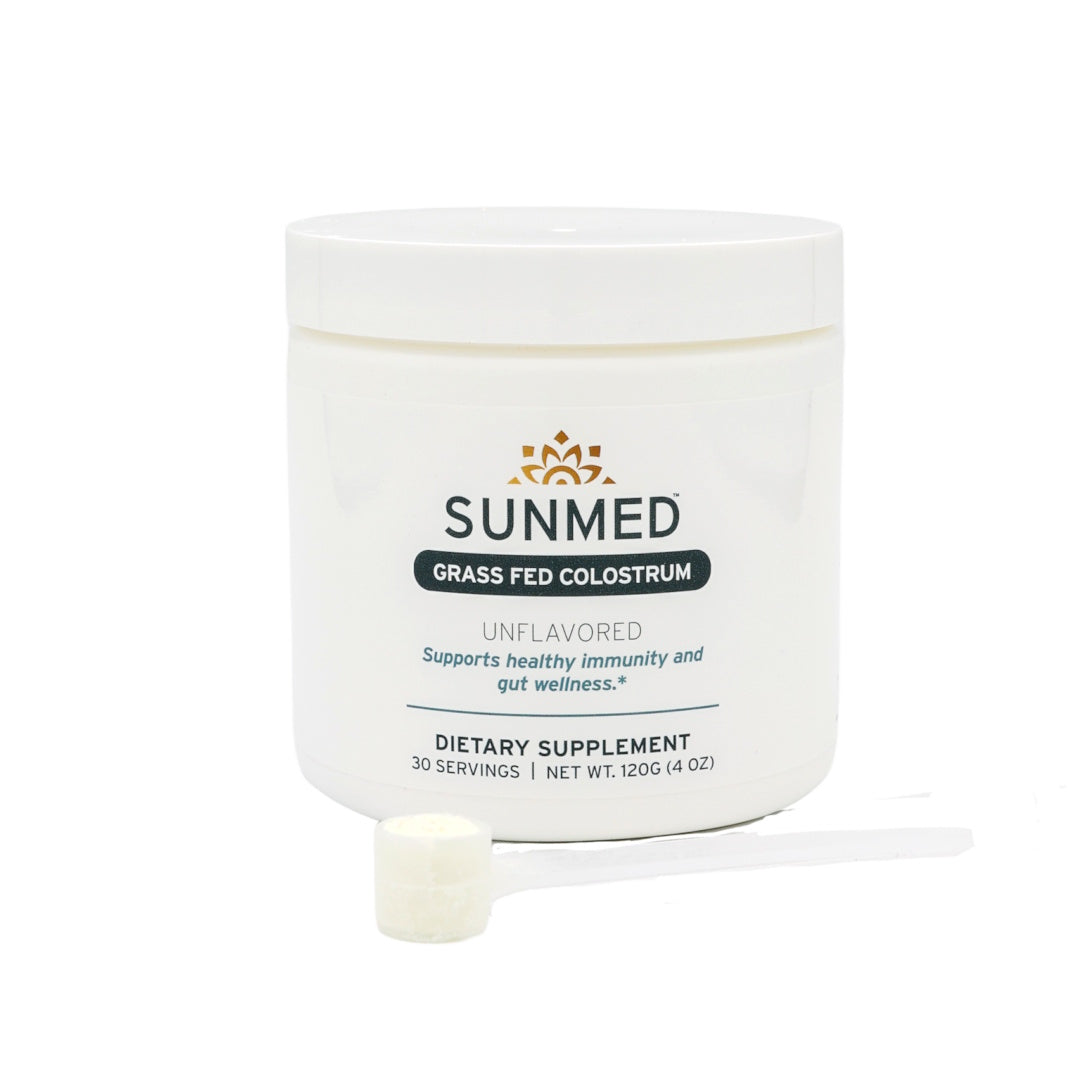White container of Sunmed CBD Grass-Fed Colostrum Powder with a scoop in front, ideal for those looking for natural immune and gut health support.
