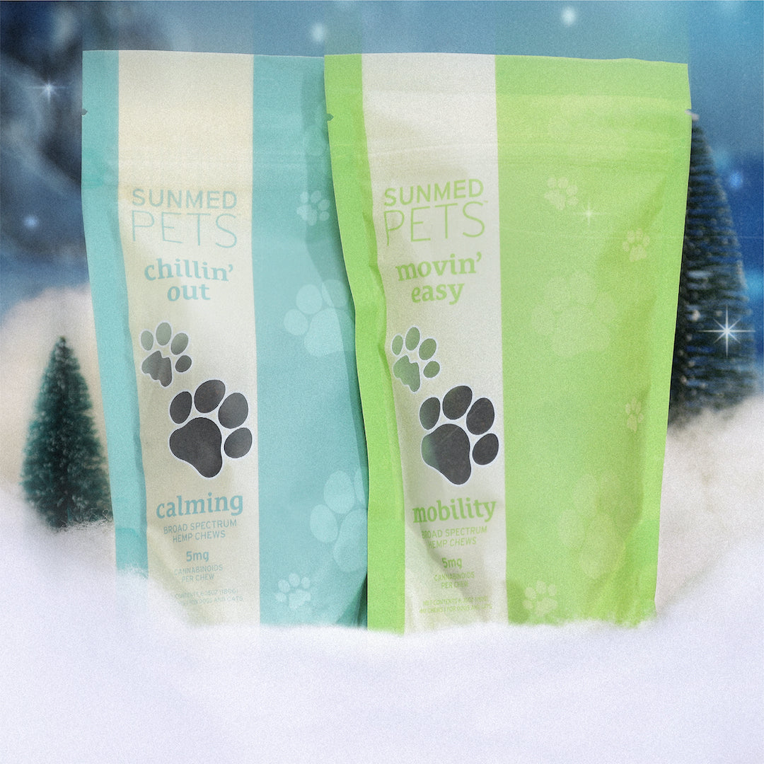 Two bags of Sunmed CBD's Chillin' Out + Movin' Easy Pet Chew Holiday Bundle, featuring paw prints and a wintry background, labeled as "calming" and "mobility.