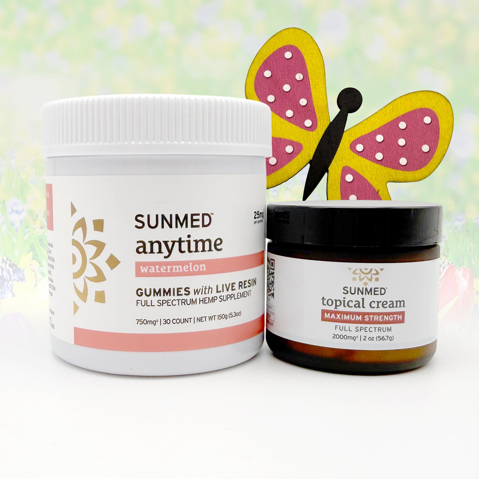 The Sunmed CBD Full Spectrum Anytime Gummies + Topical Cream Bundle, decorated with a paper butterfly, sits on a pastel floral background, showcasing the elegance of this CBD wellness set.