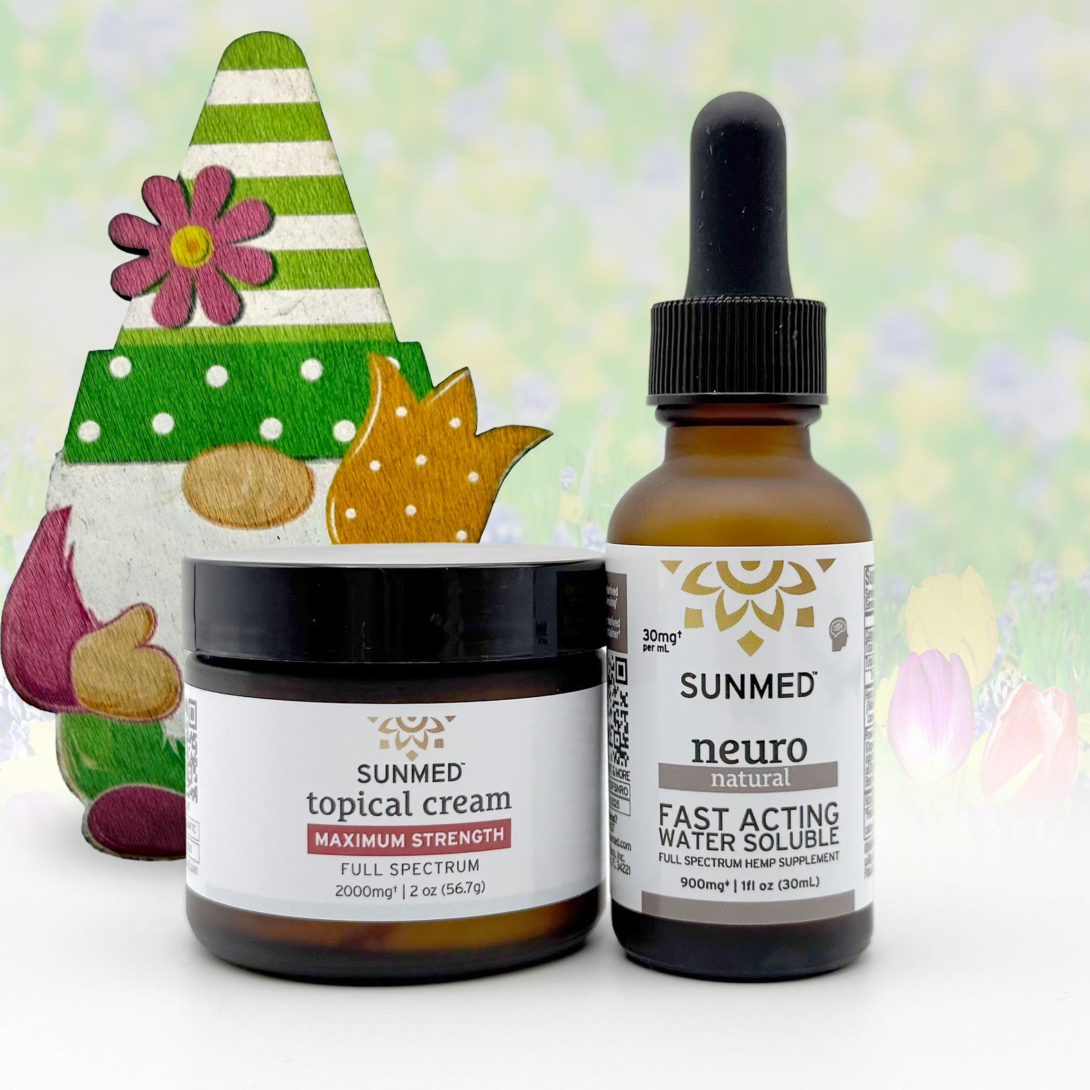 Two Sunmed CBD jars—the Full Spectrum Neuro Water Soluble + Topical Cream Bundle—are set before a spring gnome and a floral, pastel background.