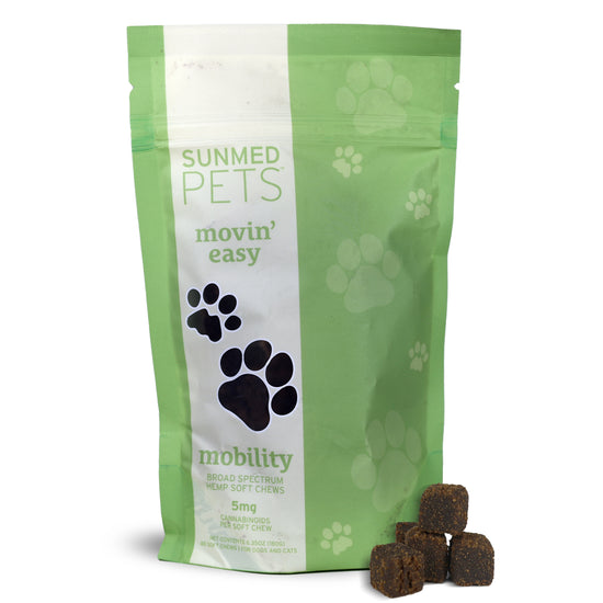 A green bag of Sunmed CBD Broad Spectrum Movin’ Easy Relief CBD Pet Chews for dogs and cats, with a few chews displayed in front of the bag.