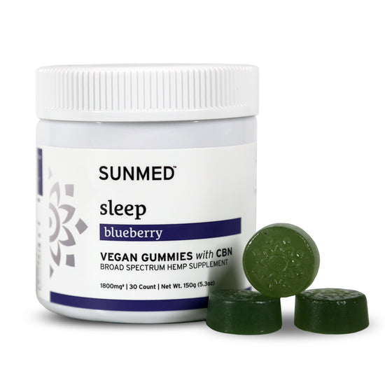 A jar of Sunmed CBD Broad Spectrum Sleep CBN Gummies with three green gummies in front, ideal as a natural sleep aid.
