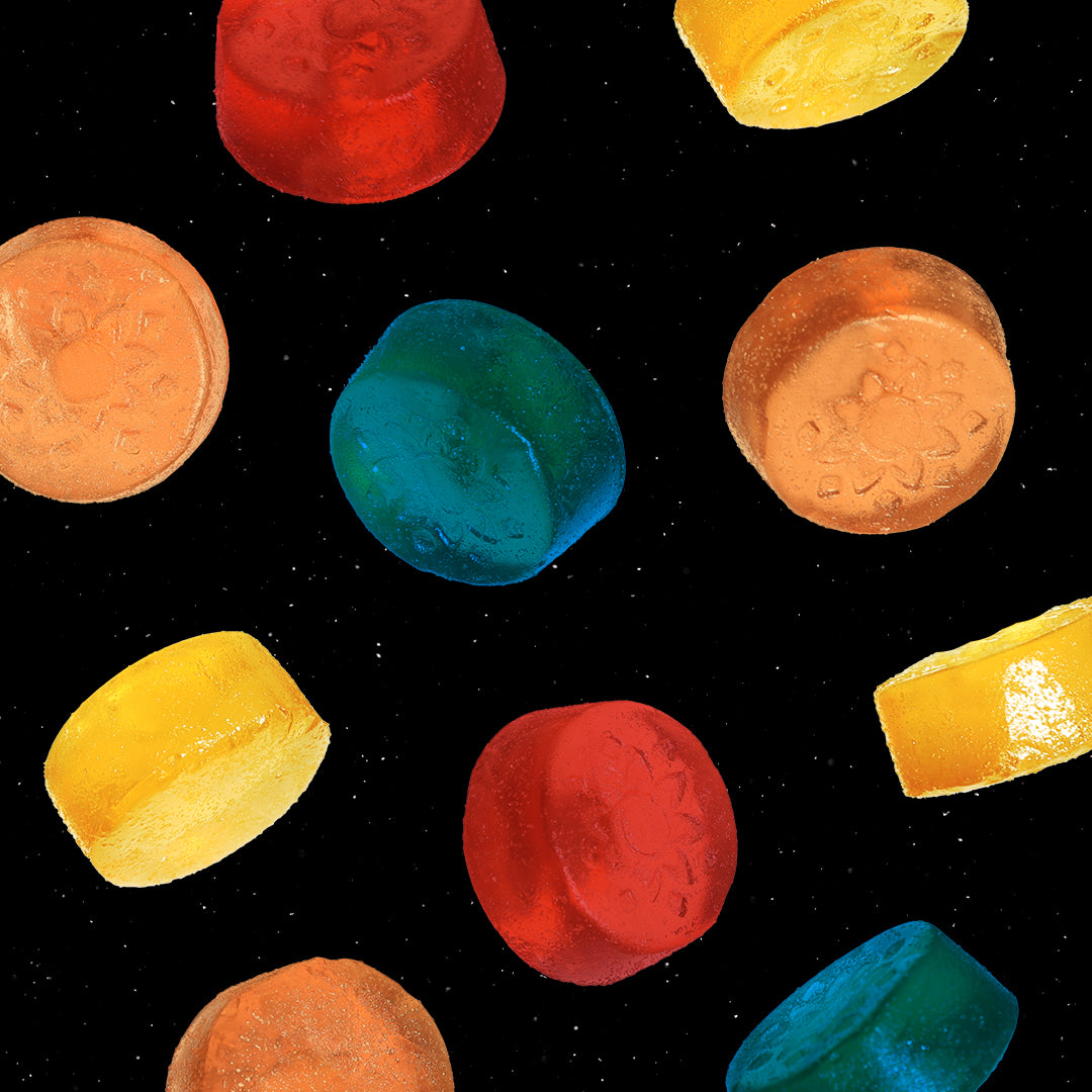 Sunmed CBD's Above Delta-8 Full Spectrum Blend Gummies are scattered on a black background.