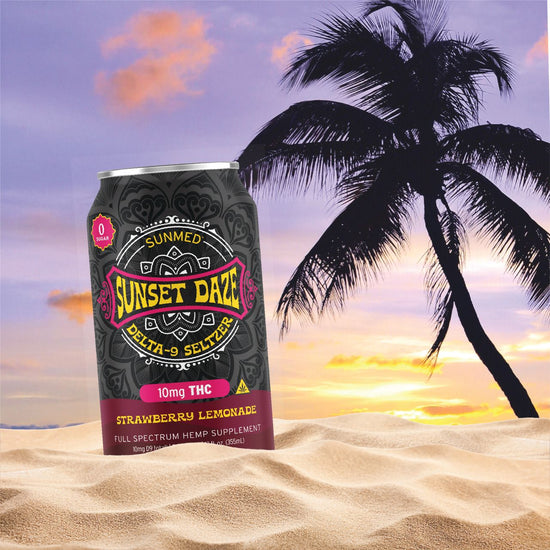 A 24-pack of Sunmed CBD Sunset Daze Delta 9 THC Seltzer in Strawberry Lemonade flavor sits on the sand with a palm tree and sunset backdrop, capturing the refreshing vibe of this hemp beverage, perfect for unwinding.