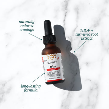 A bottle of Sunmed CBD Full Spectrum Trim Weight Loss Tincture with a pipette, placed on a marble surface, is labeled with benefits such as reducing cravings and long-lasting effects, and contains THCV extract.