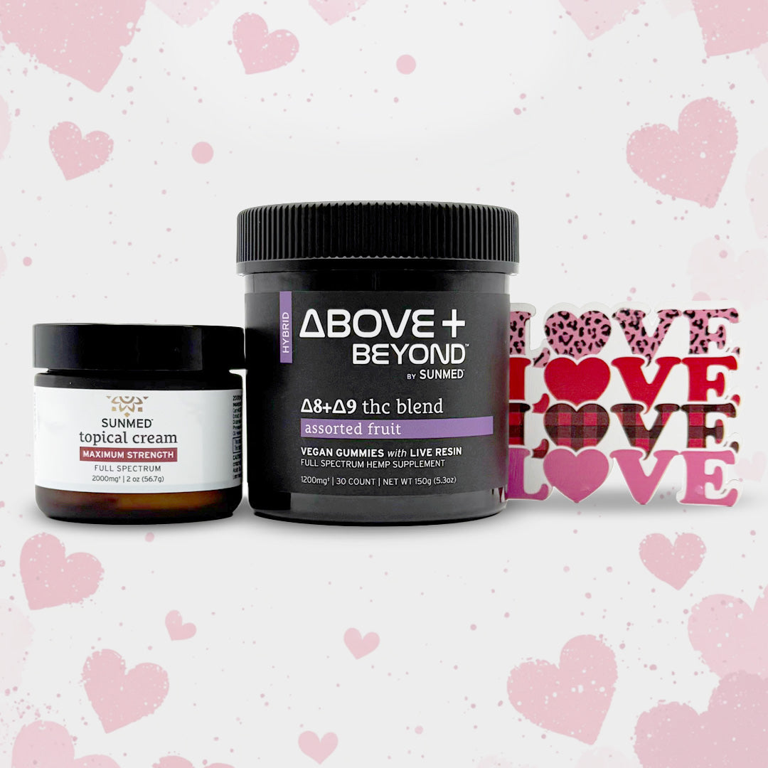 The Sunmed CBD ABOVE + BEYOND Gummies + Topical Cream Bundle sits beside a decorative “LOVE” sign on a pink, heart-patterned background.