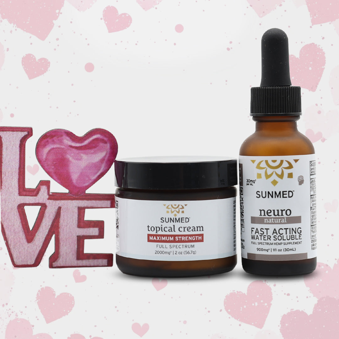 The Sunmed CBD Full Spectrum Neuro Water Soluble + Topical Cream Bundle sits beside a pink "LOVE" sign with a heart, set against a light background with pink hearts.