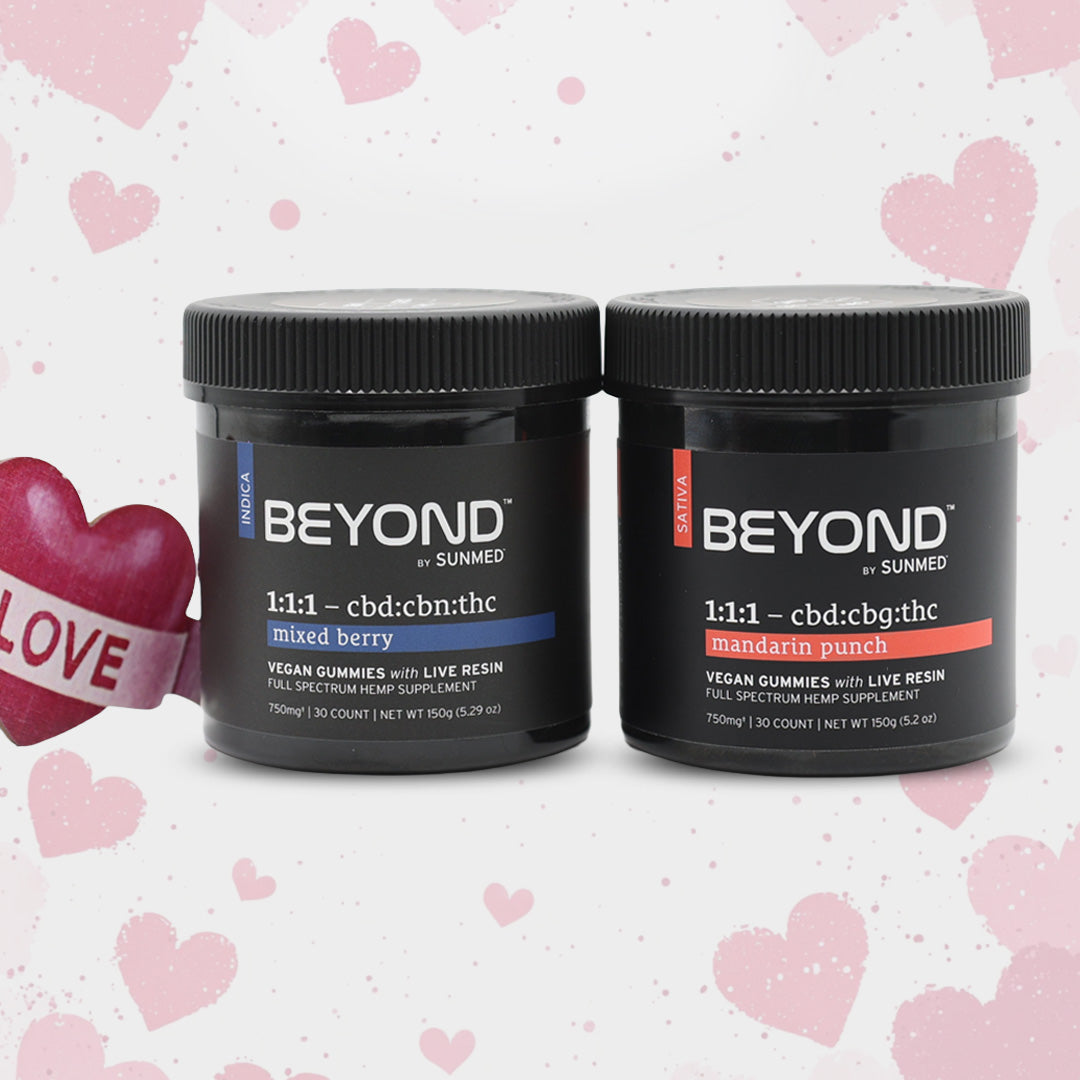 Two jars of the Sunmed CBD BEYOND Sativa + Indica Gummies Bundle are surrounded by hearts, with a “LOVE” heart placed on the left.