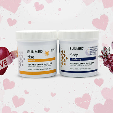 Two jars of Sunmed CBD Full Spectrum Sleep + Rise Gummies Bundle—caffeine-free energy gummies (mango) for morning and sleep gummies (blueberry) for night—sit on a pink heart background.