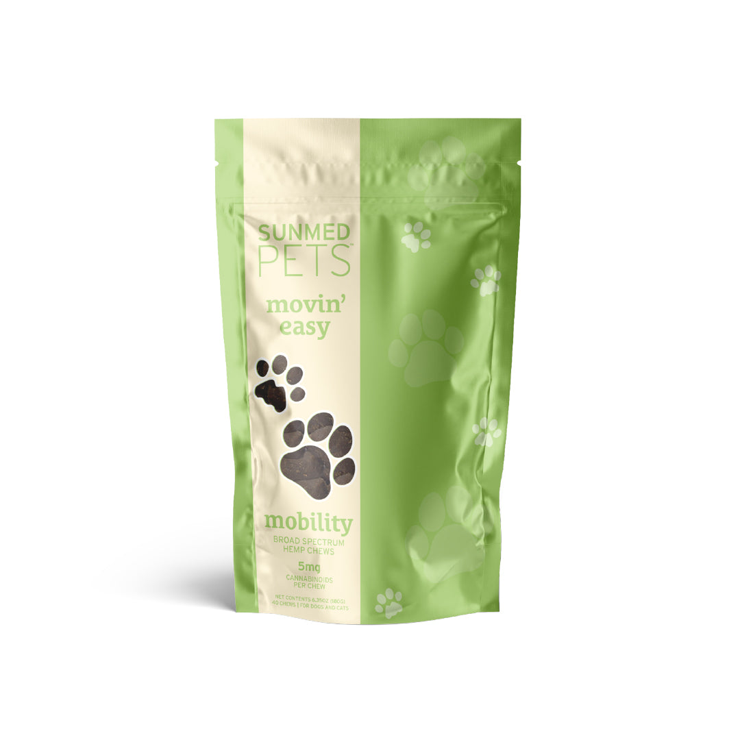 A green and white pouch of Broad Spectrum Movin’ Easy Relief CBD Pet Chews from Sunmed CBD, featuring paw prints on the package and formulated by veterinarians with broad spectrum hemp extract.